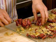 Cooking Channel serves up this Garlic-Stuffed Lamb Loin Bites recipe from Michael Chiarello plus many other recipes at CookingChannelTV.com