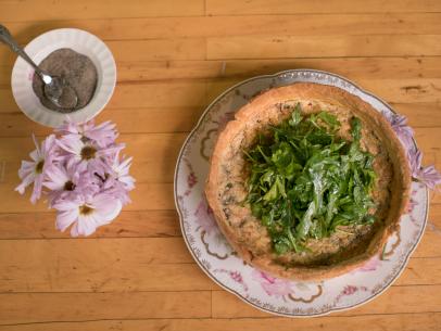 A savory pie of egg, potatoes, bacon, mushrooms and gruyere cheese topped with a leafy herb green salad tossed with oil and lemon juice in a pecorino & pepper piecrust as prepared at Prairie Ranch in Austin, TX as seen on the Cooking Channel's Haylie's America episode 103.