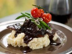 Cooking Channel serves up this Braised Short Ribs on Garlic Mashed Potatoes with Green Beans and Poached Tomatoes recipe from Chuck Hughes plus many other recipes at CookingChannelTV.com