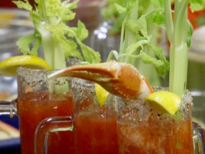 Snow crab bloody caesar garnished with a snowcrab leg, lemon wedge, and stalk of celery.
