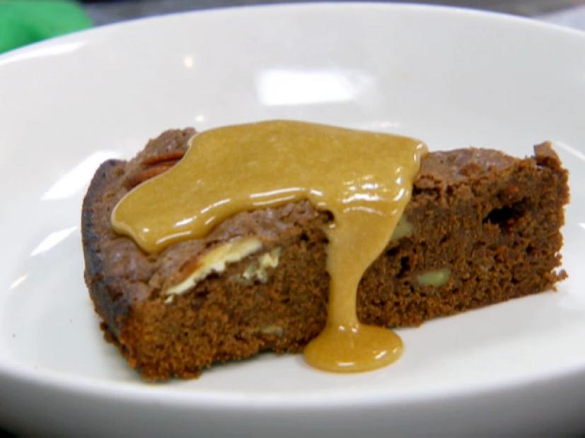 A slice of brownie topped with caramel sauce.