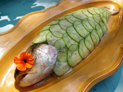 Whole trout , sea salt and fillet knife on turquoise wooden table , fresh  unscaled fish , entrails removed , top view Stock Photo