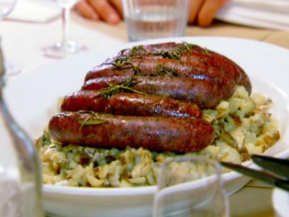 Potato risotto topped with pan grilled lamb sausages and rosemary.