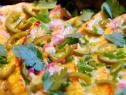 Plaintain gratin is topped with white cheddar, green onions, cilantro with a pickled topping.