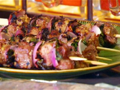 Lamb kebabs with red onion, herbs, and tamarind sauce.