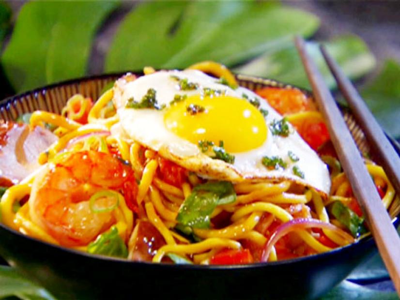 Shrimp stir fry with egg noodles, spinach, and green onion topped with a fried egg.