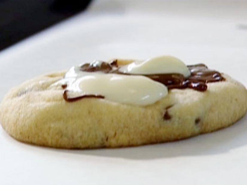 A basic cookie has melted chocolate and white chocolate drizzled on top.