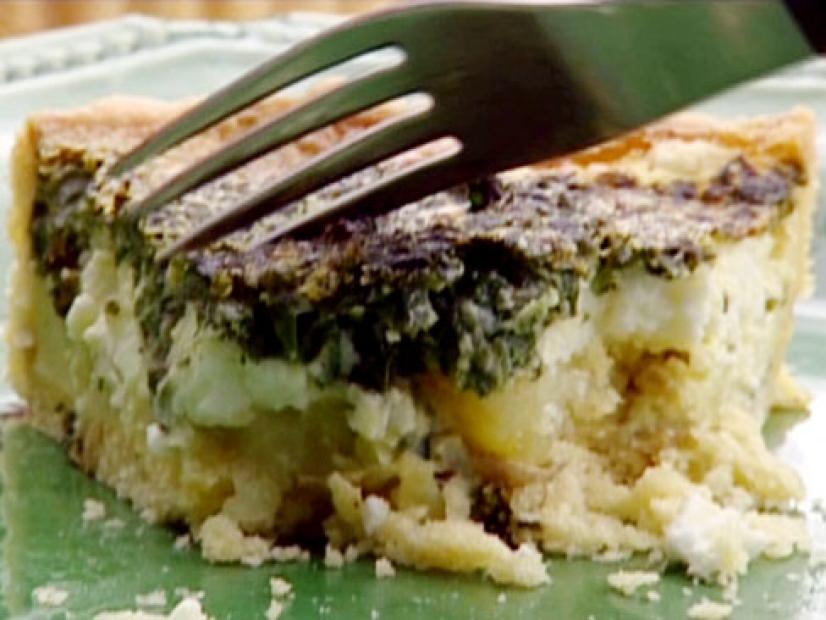Spinach potato and goats cheese tart is layered with the spinach on top.