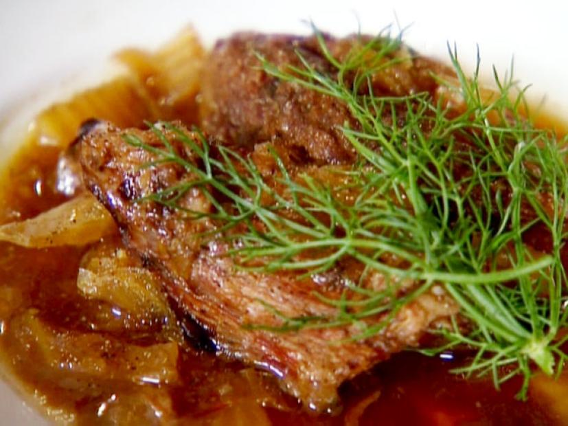 Beef cooked with onions and fennel in beer. The beef is garnished with fennel fronds.