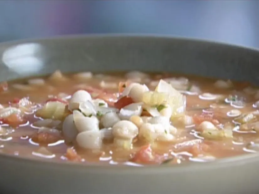 White bean and chorizo soup served in a green bowl.