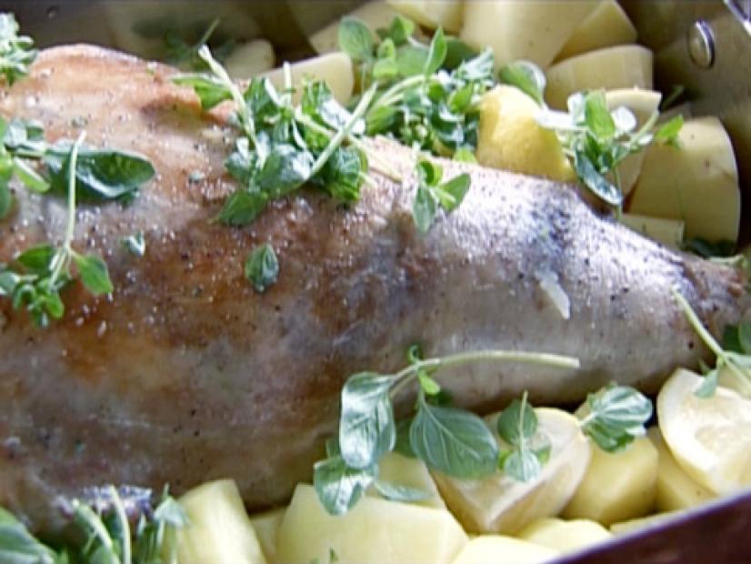 Greek lamb is slow cooked with chunks of potatoes and oregano leaves.