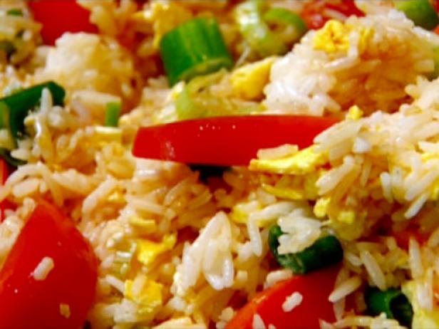 Egg fried rice with scrambled eggs, tomatoes, soy sauce, and sliced green onion.