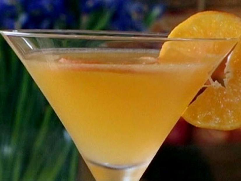 Clementine cosmo is served in a martini glass and garnished with a slice of clementine.