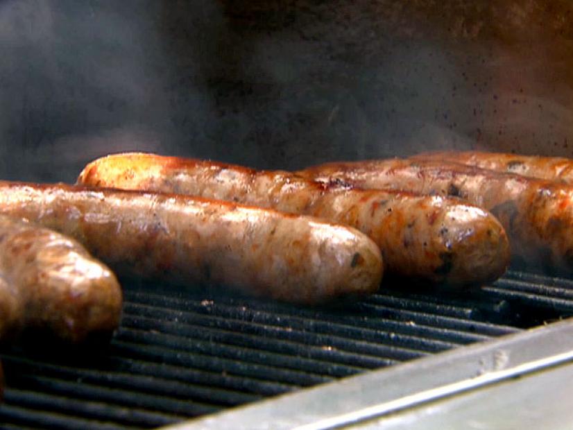 Several pieces of cooked sausage on a barbecue grill