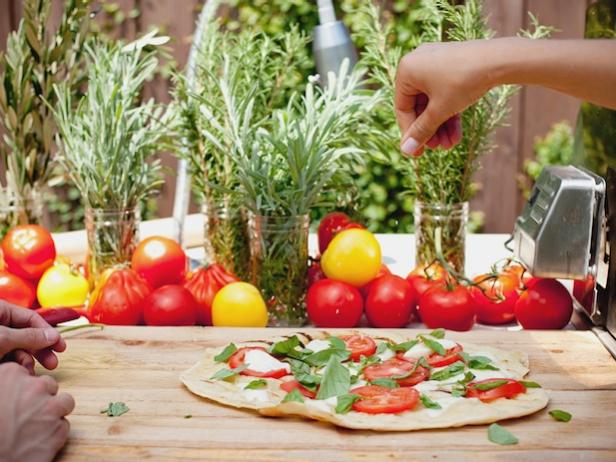 How to host a Pizza Night, where guests pitch in to make gourmet pizzas on the grill or in the oven.