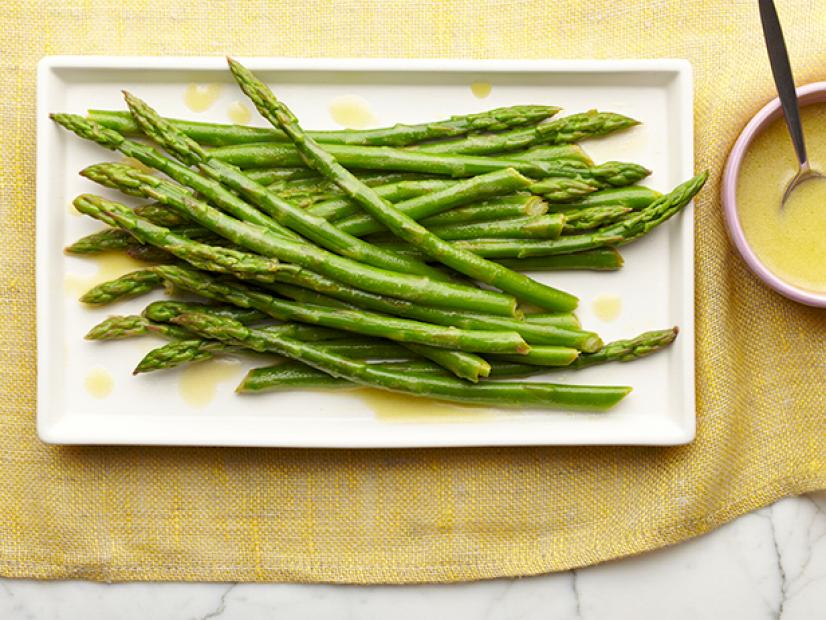 Lemon sauce is tossed over asparagus.