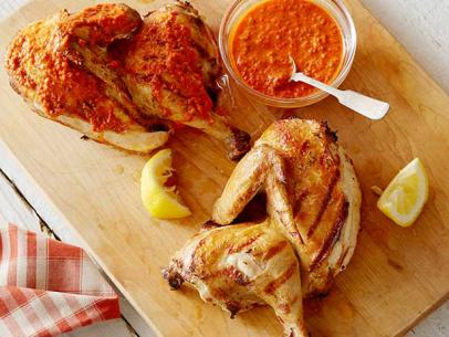 Grilled chicken covered with harissa placed on a yellow plate