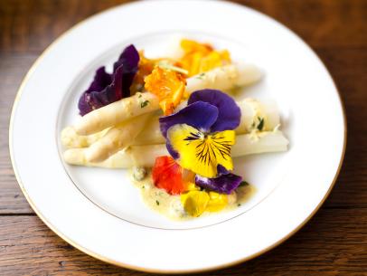 Local white asparagus served with Gribiche sauce and decorated with edible flowers, as prepared by host Sarah Sharratt on UpRooted.