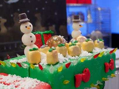A detail of the green team's creation for Santa's Mega Challenge: Ultimate Christmas Lights, depicting a lit up Mardi Gras streetcar driven by Santa and his elves, as seen on Food Network's Cake Wars, Christmas Special.
