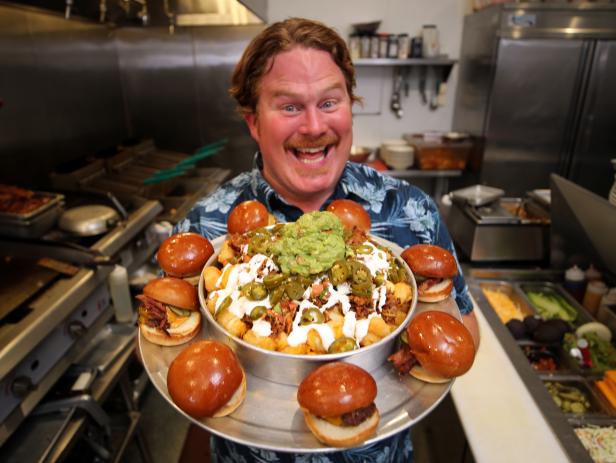 Host Casey Webb poses with the Tot-Cho Bro Challenge at Libertine Brewing Company in San Luis Obispo, CA, as seen on Man v. Food, Season 4.